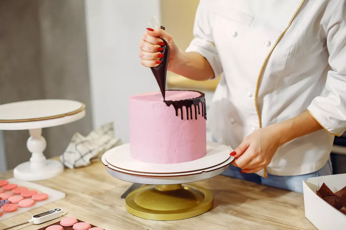 Persona decorando tarta con manga con chocolate