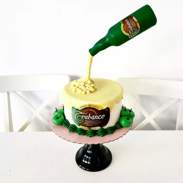 Tarta decorada con una botella de sidra y manzanas