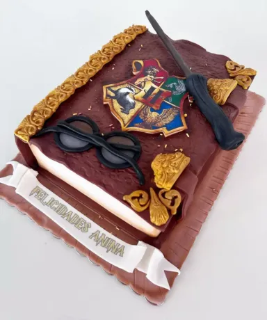 Tarta decorada como un libro de Harry Potter bajo unas gafas y una barita mágica