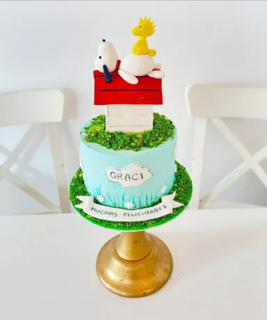 Tarta decorada con Snoopy tumbado sobre una caseta de perro