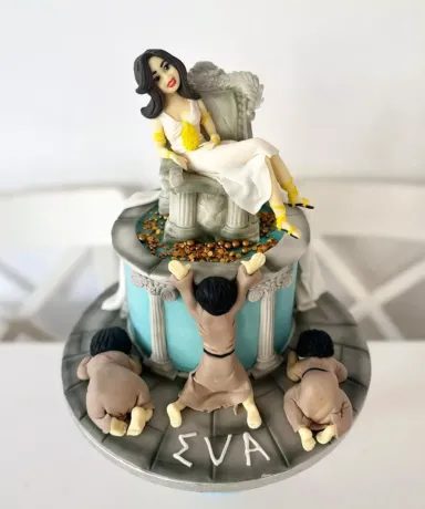 Tarta con forma de Diosa sentada en su trono mientras varias personas la veneran